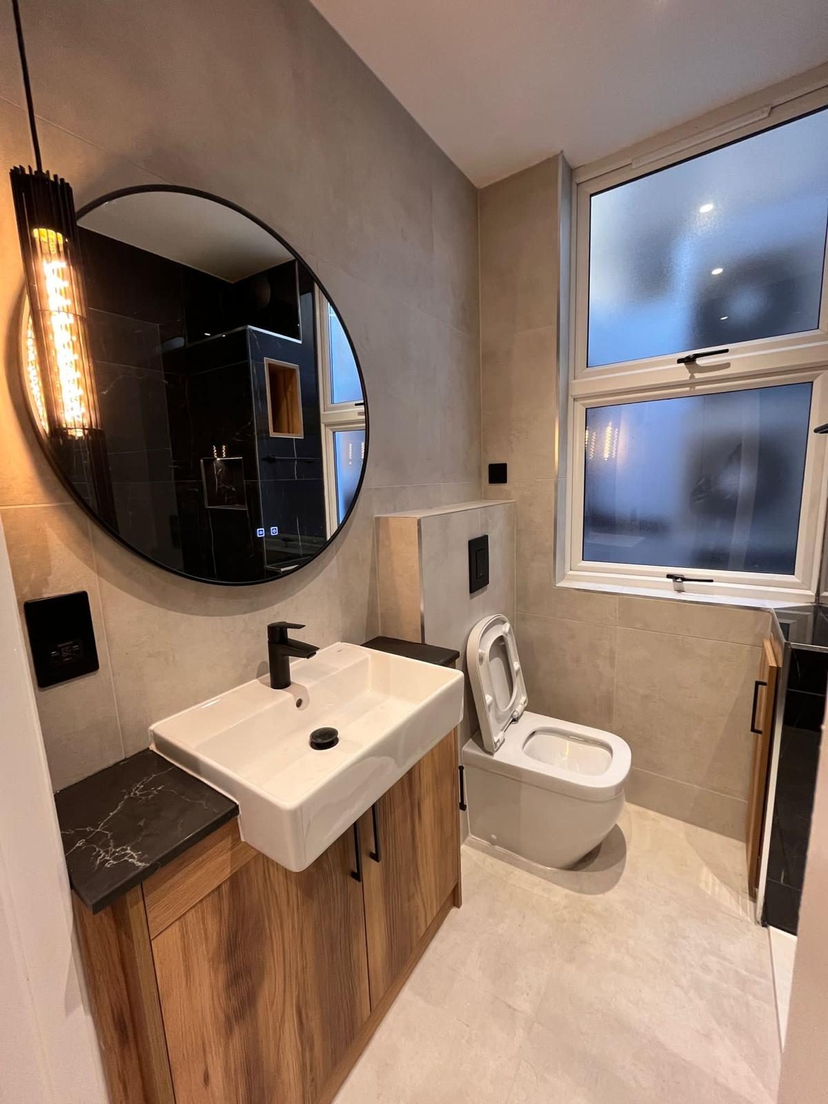 Walnut vanity bathroom with round mirror